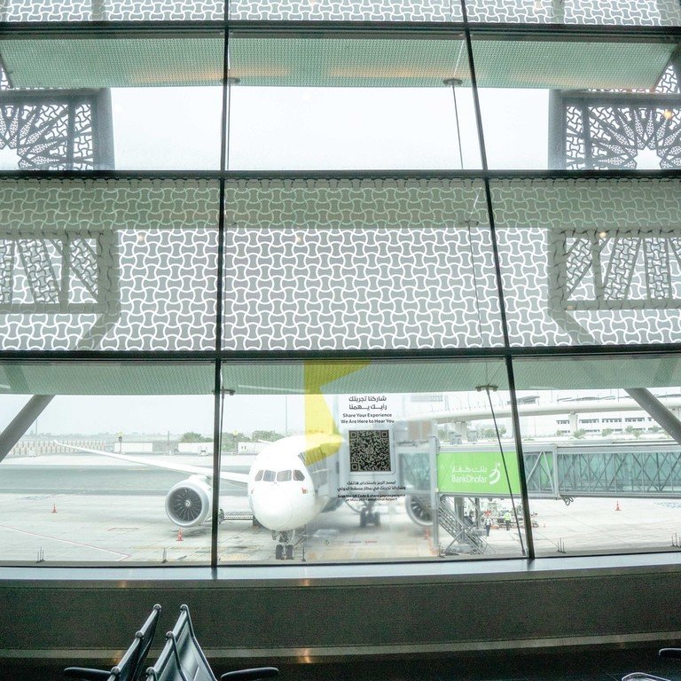 Airport terminal lounge with a plane parked at the gate